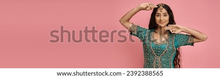 beautiful indian female model in national costume gesturing while dancing on pink background, banner