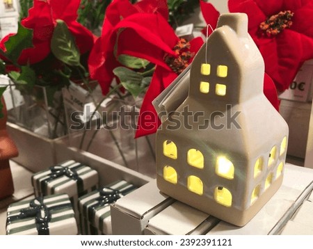 white ceramic candle holder in shape of house on showcase display at store. Christmas holiday season presents shopping.