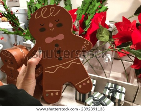 hand holding a gingerbread cookie gift box. Christmas holiday season gift shopping.