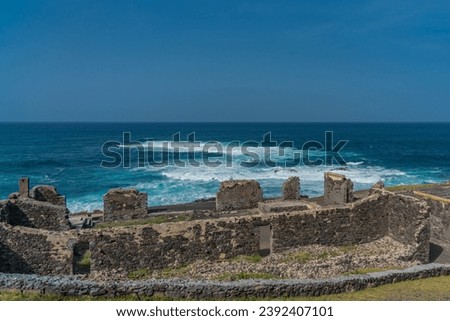 Atlantic ocean landscape with ruins of a synagogue at the north coast of Santo Antao Island, Cape Verde Royalty-Free Stock Photo #2392407101