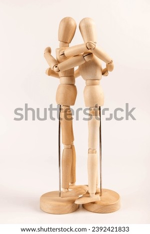 Two drawing mannequins in the act of hugging one another