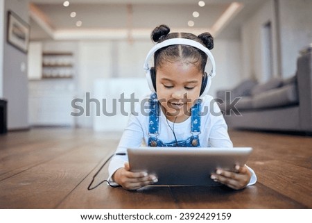 Kid, headphone and tablet for streaming in home with internet for entertainment, learning or watching. Little girl, lying and floor in living room for comfort with technology for online, web or app