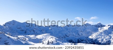 Panorama of snowy low mountains and hills on a sunny day in the foothills of the Alps