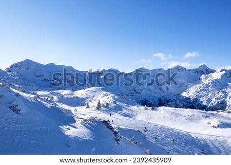 Snow slope with skiers in the foothills of the Slovenian Alps