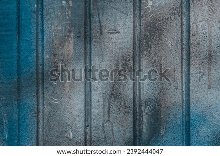 Blue paint on old dirty fence surface weathered texture background.