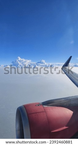 Picture of the blue sky with clouds from inside an airplane