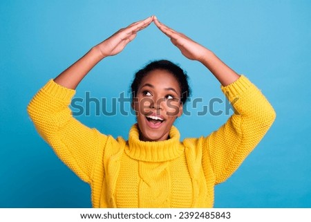 Photo portrait of woman making roof over head with hands isolated on bright colored background.