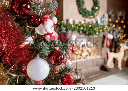 Beautiful new year room with decorated Christmas tree, gifts and fireplace with the glowing lights at night. The idea for postcards. decorated fir tree with garlands and balls