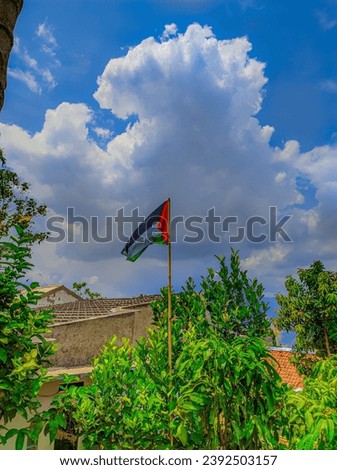 the flag flies against the bright blue sky