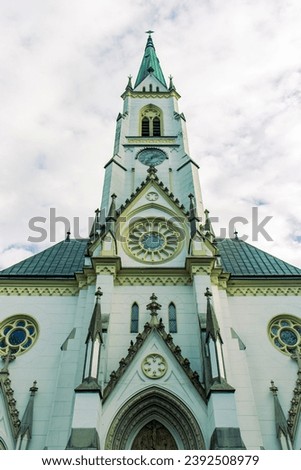 Abstract photograph of the church from the front view. Beautifully decorated church, white facade. gothic door. A built in the Gothic style. Believer, Church, God, Catholic Church.