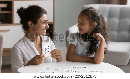 Loving Indian mother show flash cards to 6s girl, check daughter knowledge in multiplication during mathematics basic class with parent or teacher at home. Preparation for school, education concept Royalty-Free Stock Photo #2392512873