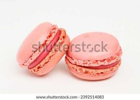 Two raspberry macarons on a white background Royalty-Free Stock Photo #2392514083