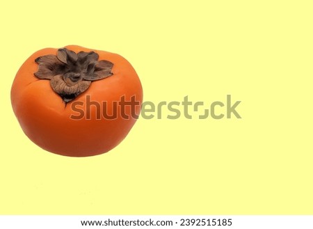 Yellow-orange persimmon fruit picture yellow background