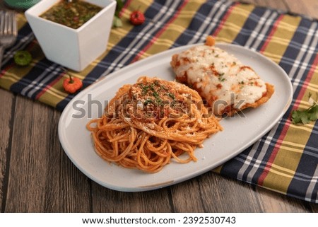Chicken parmesan with spaghetti and parsley garnish Royalty-Free Stock Photo #2392530743