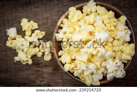 Fresh popcorn in bowl on white wooden table. Selective focus. 