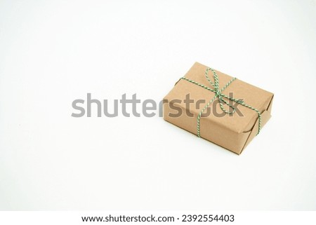 The gift is wrapped in craft paper. Isolate on a white background.