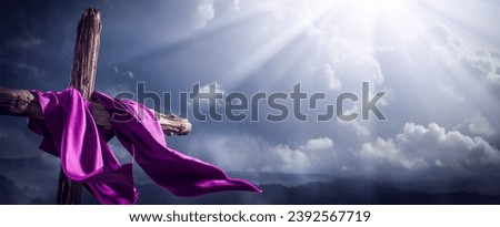 Flowing Purple Robe On Wooden Cross With Light From Heaven Shining Through The Clouds - The Resurrection And Ascension Of Jesus Christ

 Royalty-Free Stock Photo #2392567719