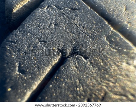 In this detailed close-up photograph, the intricate textures and patterns of a tire's rubber surface come into focus. Royalty-Free Stock Photo #2392567769
