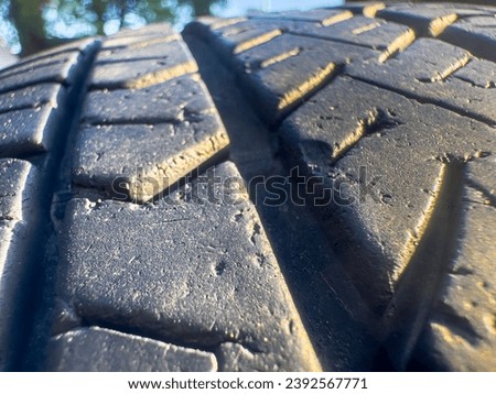 In this detailed close-up photograph, the intricate textures and patterns of a tire's rubber surface come into focus. Royalty-Free Stock Photo #2392567771