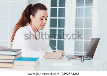 Business woman at desk using laptop online in office