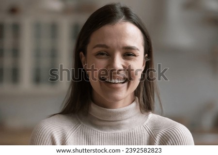 Head shot of happy 30s beautiful woman posing staring at camera. Laughing housewife or e-tutor profile picture, millennial generation person, natural beauty, authentic female close up portrait concept Royalty-Free Stock Photo #2392582823