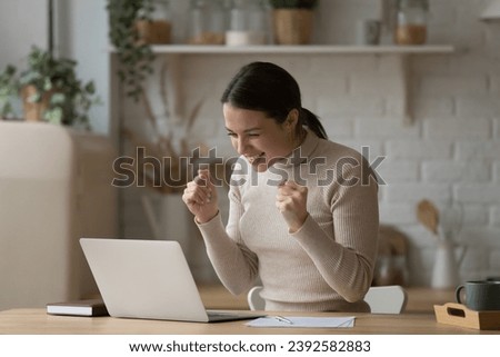 Young woman read e-mail with great news on laptop feels happy, got notice about university scholarship or admission, got special commercial offer, celebrate on-line auction victory, triumph concept Royalty-Free Stock Photo #2392582883