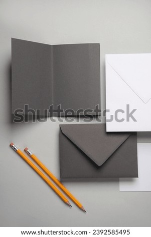 Floating envelopes and brochure, card, pens on gray background with shadow. Minimalism, modern business still life, creative layout
