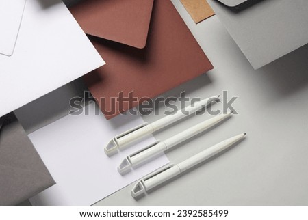 Floating envelopes and cards, pens on gray background with shadow. Minimalism, modern business still life, creative layout