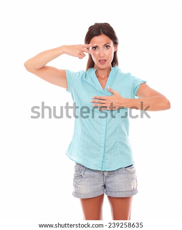 Stylish hispanic woman making a victory sign while looking at you standing in white background