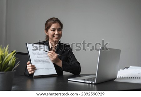 Young business woman introduces making a contract or submitting a signature. Business signing through online platforms on laptop