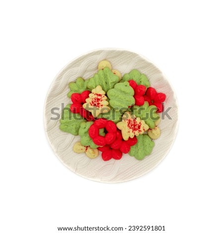 Round platter full of christmas spritz cookies in red, green, and white with red sanding sugar in tree, ornament, and poinsettia flower shapes Royalty-Free Stock Photo #2392591801
