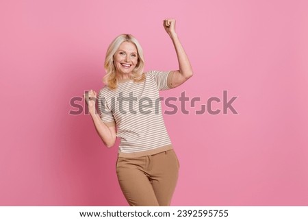 Photo of overjoyed cheerful good mood lady raise hands fists rejoice celebrate holiday empty space isolated on pink color background
