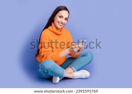 Full body size photo of lady in knitwear pullover browsing posts instagram using phone sit floor isolated on violet color background