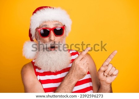 Photo of cool impressed senior guy christmas swimwear hat glasses showing two fingers empty space isolated yellow color background