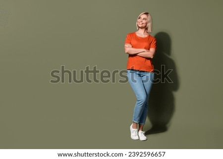 Full body length photo of attractive nice young woman wear orange t shirt crossed arms look copyspace isolated on khaki color background