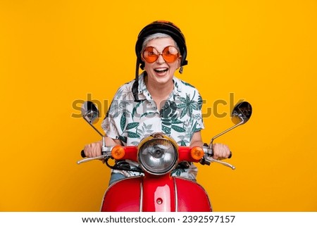 Photo portrait of nice pensioner lady drive excited scooter helmet wear trendy tropical print outfit isolated on yellow color background
