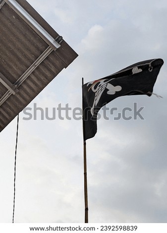 The one piece flag flies against a blue sky