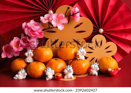 Chinese New Year of the dragon festival concept. Mandarin orange, red envelopes, dragon and gold ingot with red paper fans. Traditional holiday lunar New Year. 