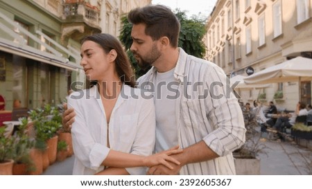Young couple city annoyed offended angry woman arms crossed guilty man apologize quarrel outside street discomfort emotions feel disagreement crisis relationship problems ignore together regret sorry