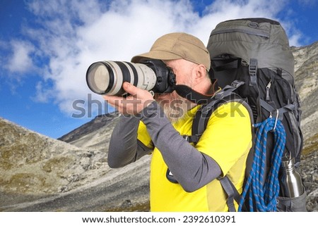 tourist photographer with a backpack photographs the beauty of nature in the mountains. nature hikes in the mountains