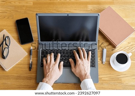 Hands of a businessman typing on a laptop