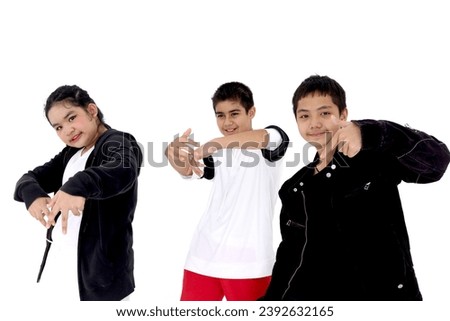 Happy student kid group studying modern style dance in studio classroom. Portrait of three children, boys and girl in casual posing on white background. Little dancers practicing break dance together.