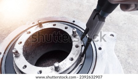 Remove the snap ring using snapring pliers in bearing replacement work. Repair bearing concept. Royalty-Free Stock Photo #2392632907