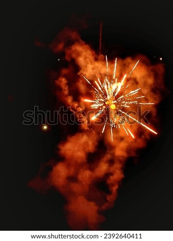 selective focus and blur on photo of red and white fireworks show in the air at night. there are white smoke and light effects
