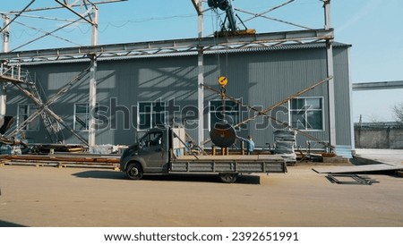 Technician worker using hoist crane for lifting metal detail in workshop factory. Creative. Work process and machinery.