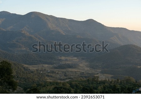 The beauty of the sunset over the rolling hills in the Himalaya Foothills of Nepal. Royalty-Free Stock Photo #2392653071