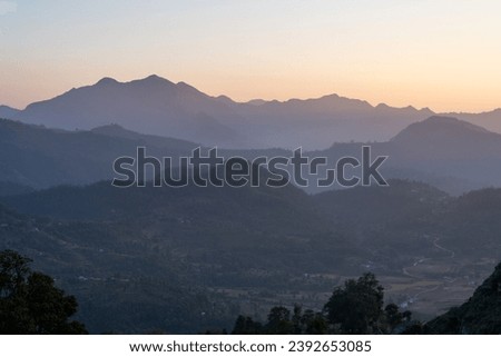 The beauty of the sunset over the rolling hills in the Himalaya Foothills of Nepal. Royalty-Free Stock Photo #2392653085
