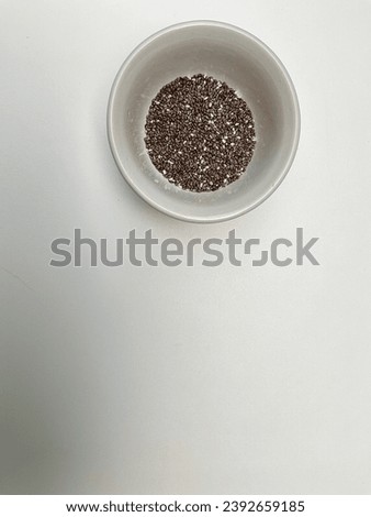 Chia seeds in white bowl. Chia seeds may be added to other foods as a topping or put into smoothies, breakfast cereals, energy bars, granola bars, yogurt, tortillas, and bread