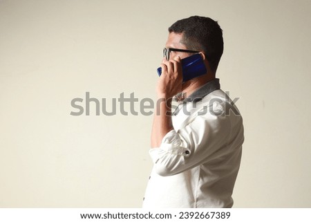 Side view of an adult man answering a telephone call