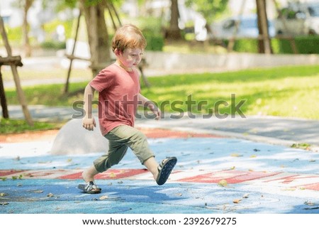 happy playful boy fun laugh smiling kid enjoy playing activity at the playground outdoor park summer.